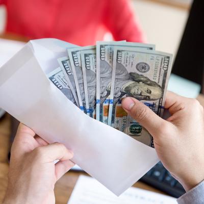 Banknotes being counted before enclosing in an envelope for payment.