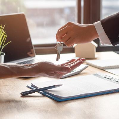 A landlord hands over keys of property to approved tenant.