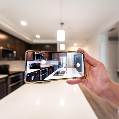 An apartment owner taking a photo of the interior of their property for marketing.