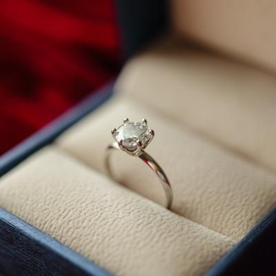 A diamond engagement ring safely kept in a jewelry box/ring holder.