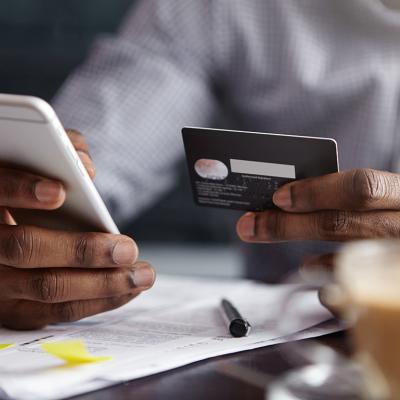 Businessman using a corporate card for a purchase using a mobile phone.