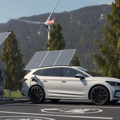 An electric vehicle being charged in a wide lot with a scenic background.