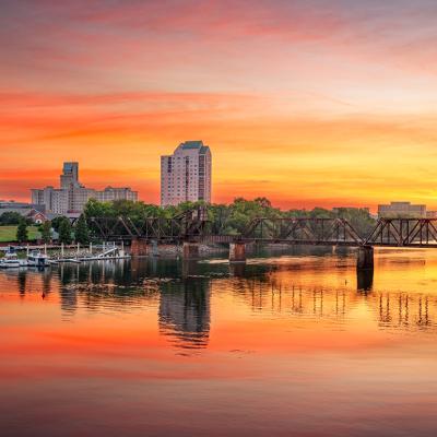 A downtown skyline view of the Savannah River, GA during sunset.