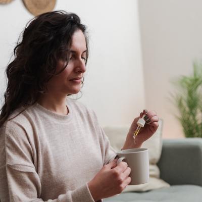 Woman holding pipette of medical cannabis oil.