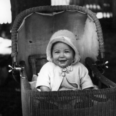 Happy baby in a buggy in the late 1930s.