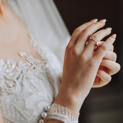 Close up on a bride's dress and ring during her wedding day.