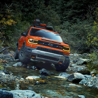 An orange 2026 Honda Passport on a rocky river road.