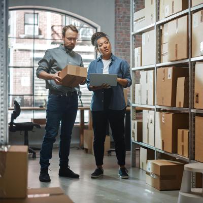 Two small business owners carefully inspecting products and inventory area.