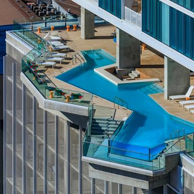 A view of a bright blue modern luxury pool on an outdoor terrace in a residential skyscraper building in downtown Austin, Texas.