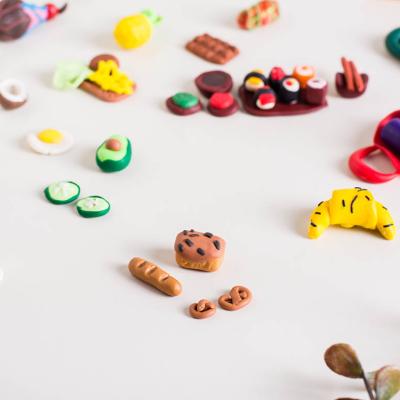 Miniature food such as baguette, breads, and fruits made out of polymer clay.