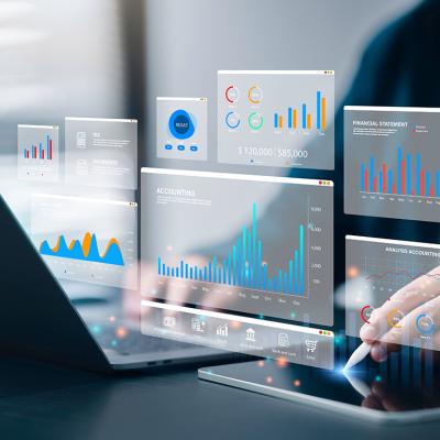 Accountant using a laptop and digital tablet with holographic visualizations of an accounting software.