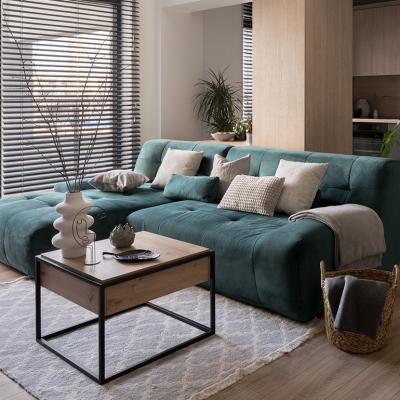 A two-piece blue-green corner sofa set placed in a modern living room.