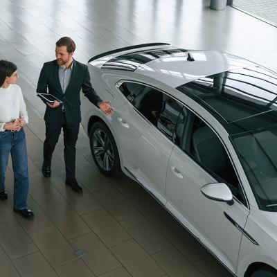 A woman choosing a new car in a dealership while an agent assists.