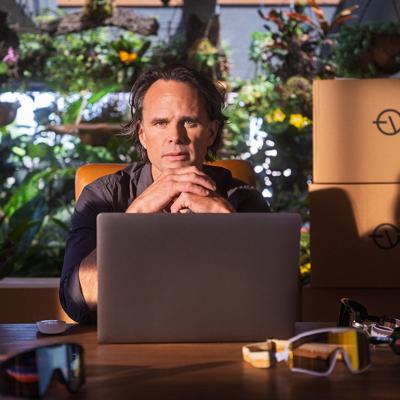 Actor Walton Goggins posed in front of a workspace and a laptop.
