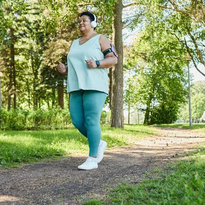 A senior black woman enjoying a morning run in a park.