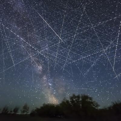 Long-exposure taken over 30 seconds showing many satellites moving across the night sky appearing as dotted lines.