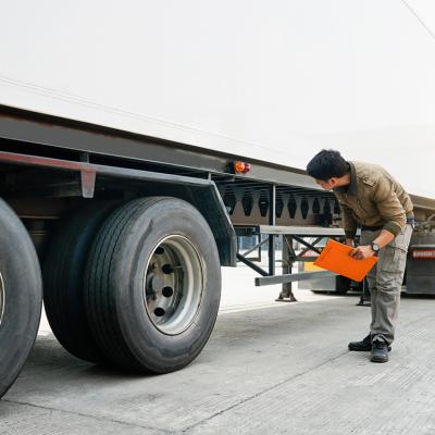 A mechanic inspecting a cargo truck for transport.