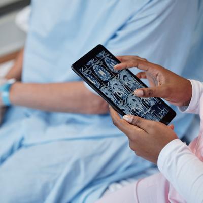 A doctor examines scan results of the head and brain beside a concussion patient.