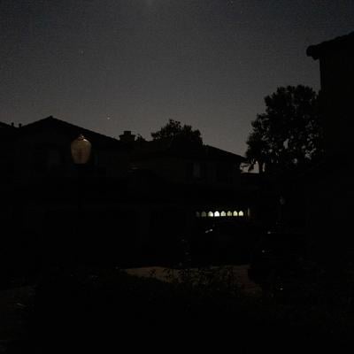 A suburban street in San Ramon, California is entirely dark except for a garage illuminated by a battery powered lantern during the Pacific Gas and Electric Public Safety Power Shutoff in 2019.