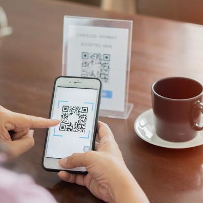 A customer scans a cafe's QR code for payment.