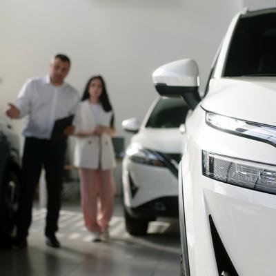 A car agent helps a woman look for a car to purchase.