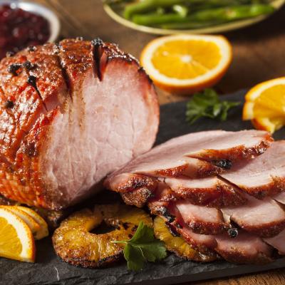 Sliced honey-glazed ham with pineapple.