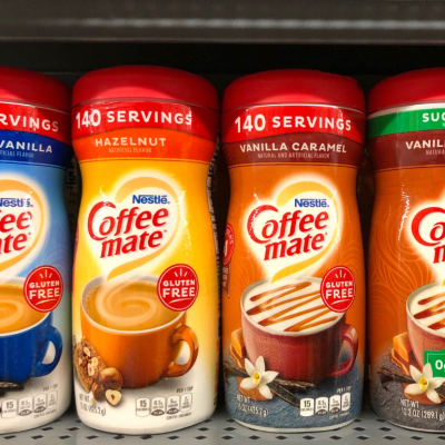 Grocery store shelf with containers of Nestle brand Coffee mate creamers in various flavors.