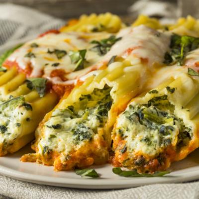 Homemade suffed ricotta and spinach manicotti with basil.