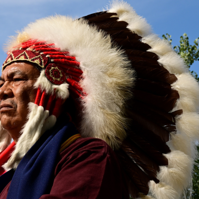Northern Cheyenne tribal chief Anthony Spottedwolf listening to Cheyenne and Arapaho tribal members perform in a drum circle as they play a traditional flag and memorial song during a gathering at the Sand Creek Massacre National Historic site on October 5, 2022