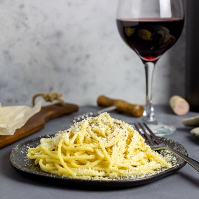 Roman pasta spaghetti cacio e pepe with black pepper, cheese, and wine.