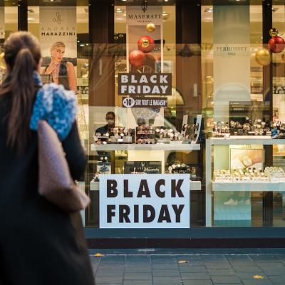 Person standing in front of a shop on Black Friday.