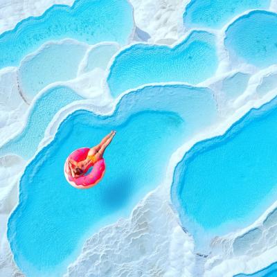 Person on pink inflatable donut in Travertine pools in Pamukkale, Turkey.