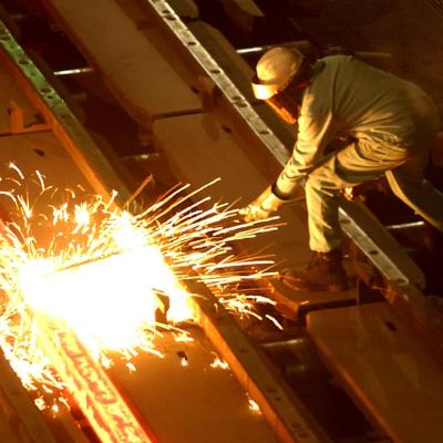 A worker cuts through a glowing 2,000 degrees Fahrenheit "billet" at the TAMCO steel mini mill