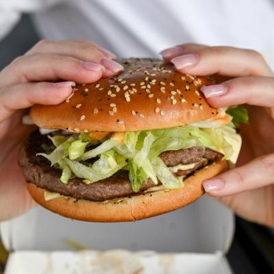 A photo of a woman holding a burger with two hands