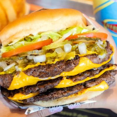 Hand holding a massive cheeseburger from Fatburger