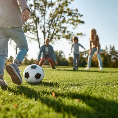 Kids playing soccer in park.
