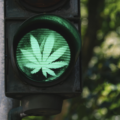 A traffic light with a green cannabis leaf.