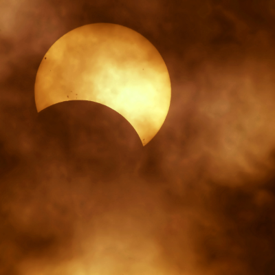 The beginning of a solar eclipse as seen through very light cloud cover.