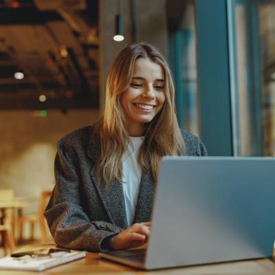 Stylish woman working on a laptop while sitting in cozy cafe.