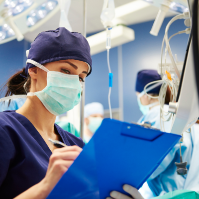 A medical technician takes notes in an operating room.