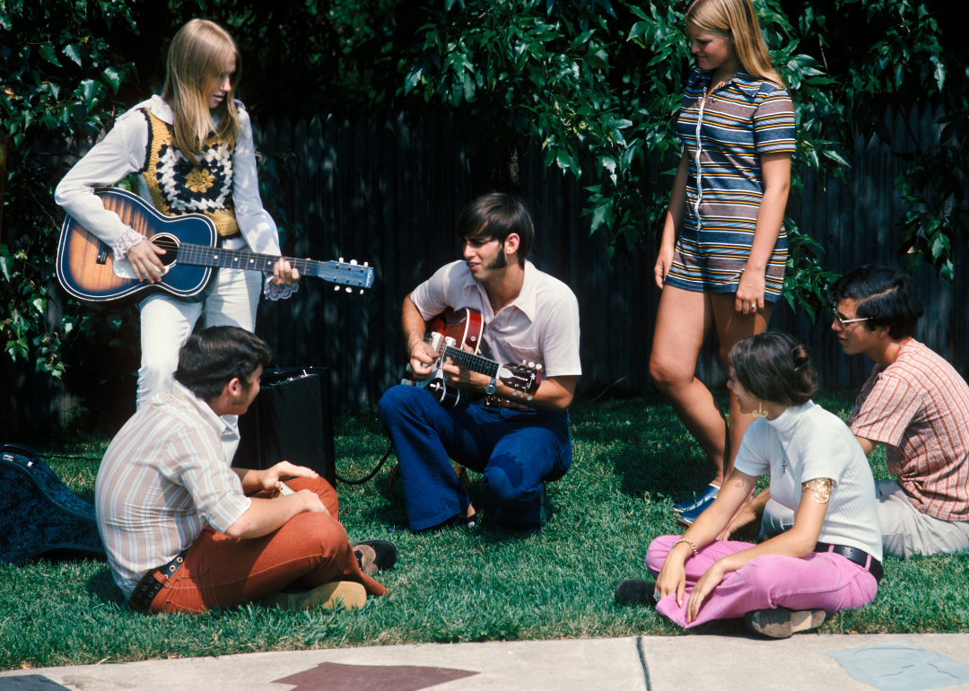 A group of teenagers playing guitar and hanging out in August 1972.