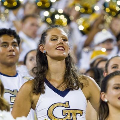 Georgia Tech Yellow Jackets cheerleaders stand in crowd.