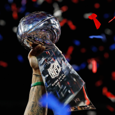 A New England Patriots player raising the Vince Lombardi Trophy.