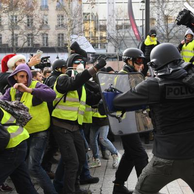 Riot police clash with men wearing yellow vests