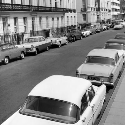 Parked cars on a street, circa June 1960.