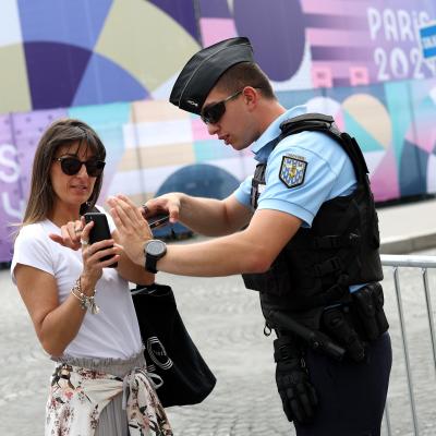 People show their QR access code to get into the Olympics.