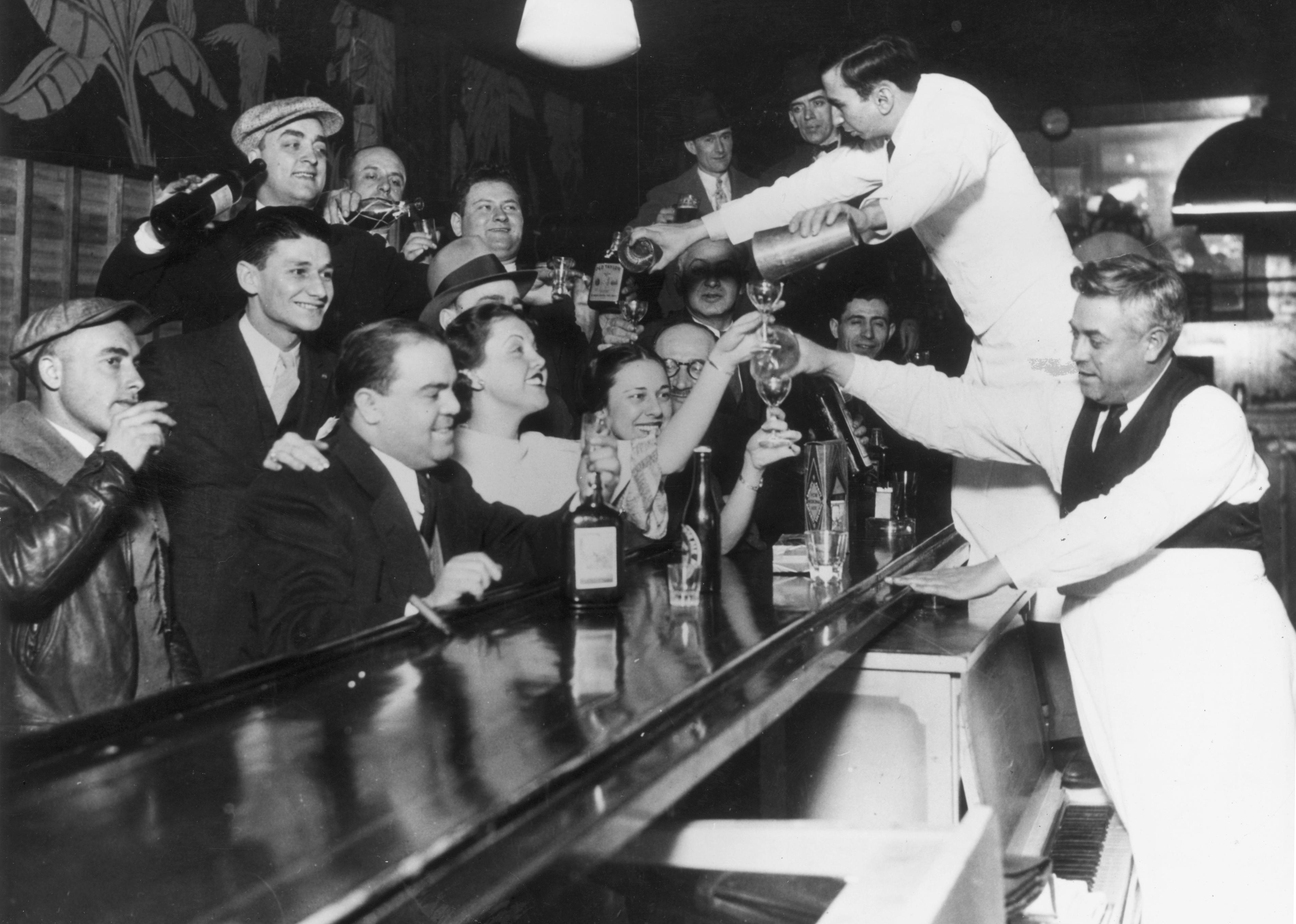 Bartenders at Sloppy Joe's bar pour a round of drinks 