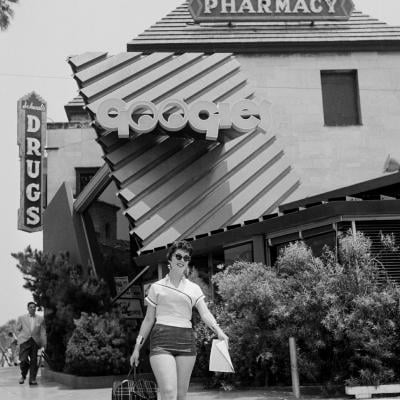 A woman walks outside Googies Coffee Shop and Schwab's Pharmacy in Los Angeles.