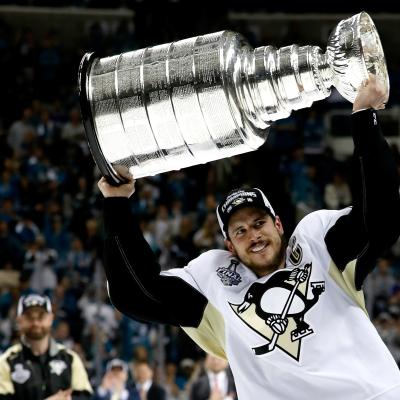 Sidney Crosby celebrates by hoisting the Stanley Cup after a victory