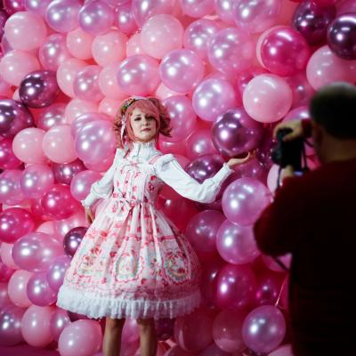 Instagram influencer "Anmaykaa" is being photographed at the "Supercandy Pop-Up Museum Vol. 2" in Cologne, western Germany with a backdrop of bright pink balloons.